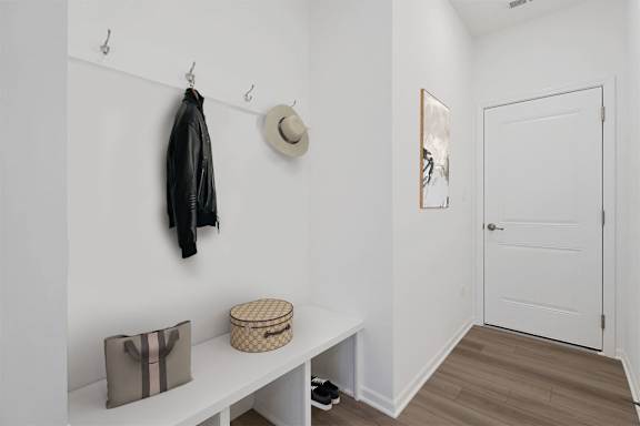 A black leather jacket hanging on a hook.