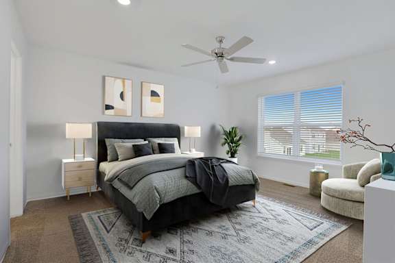 A bedroom with a large bed and a ceiling fan.