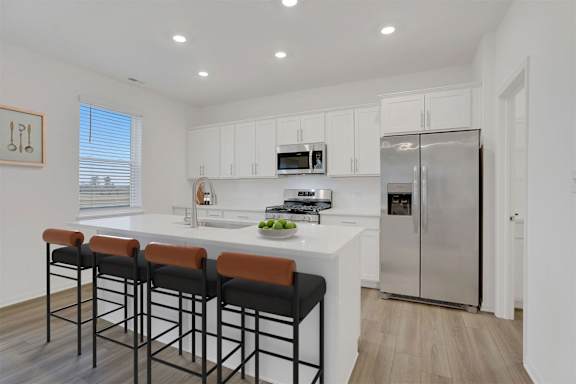 A kitchen with a white countertop and stainless steel appliances.