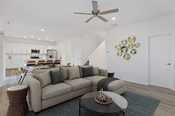 A modern living room with a beige sofa and a coffee table.