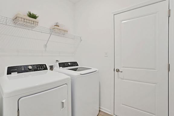 A white laundry room with a washer and dryer.