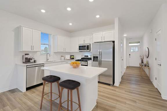 A kitchen with a white countertop and stainless steel appliances.