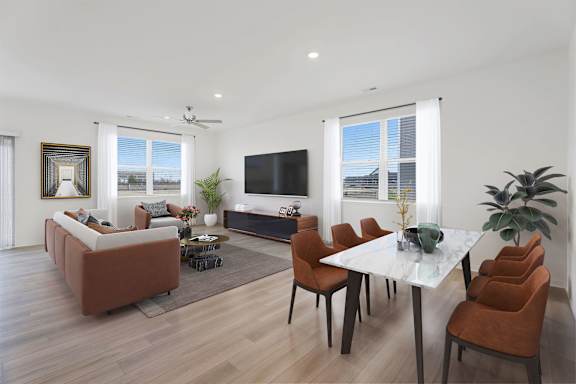 A living room with a brown sofa, a white coffee table, and a TV.
