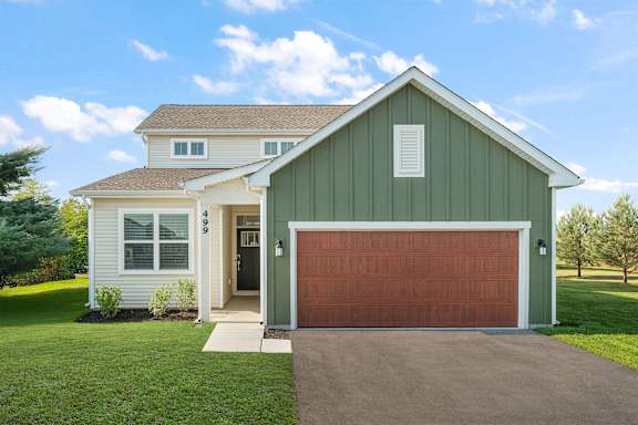 A house with a green garage door and a brown roof.