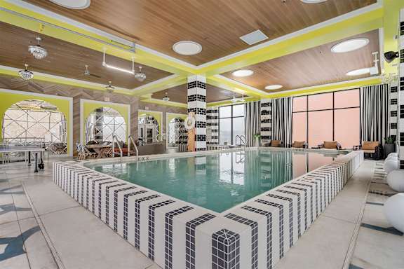 A large indoor swimming pool with a striped tile border.