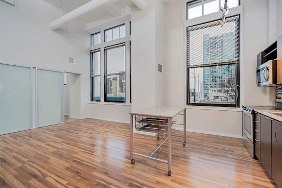 A kitchen with a table and a window overlooking a city.