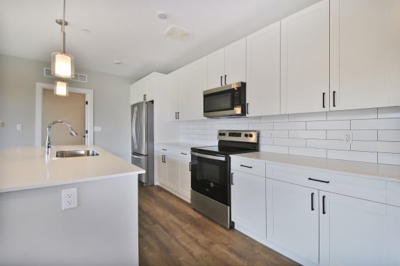 a kitchen with white cabinets and a sink and a refrigerator