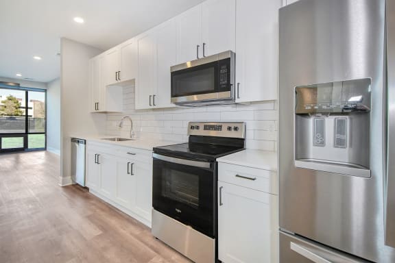 a kitchen with white cabinets and a stove and a microwave