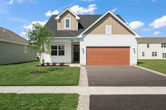 A two-story house with a garage door and a driveway.