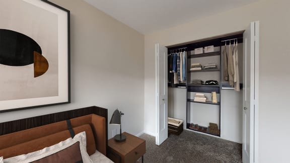 a bedroom with a bed and a nightstand with a lamp and a closet with a sliding