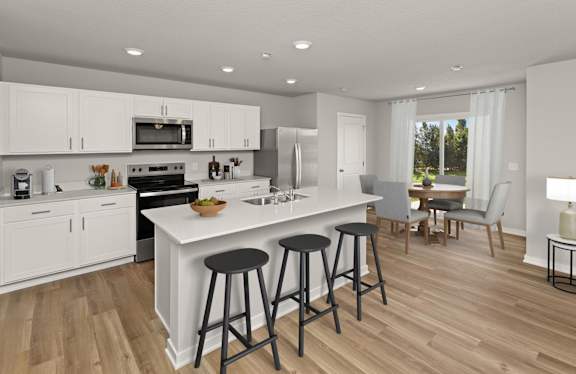 A modern kitchen with white cabinets and a large island.