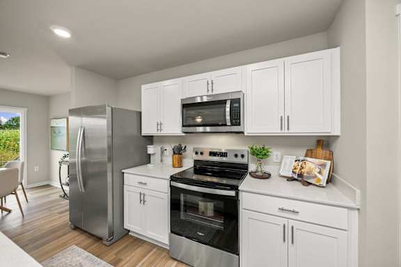 A modern kitchen with white cabinets and stainless steel appliances.