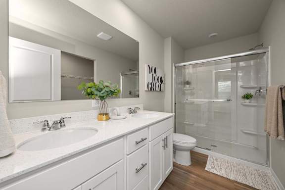 A bathroom with a white sink and toilet.