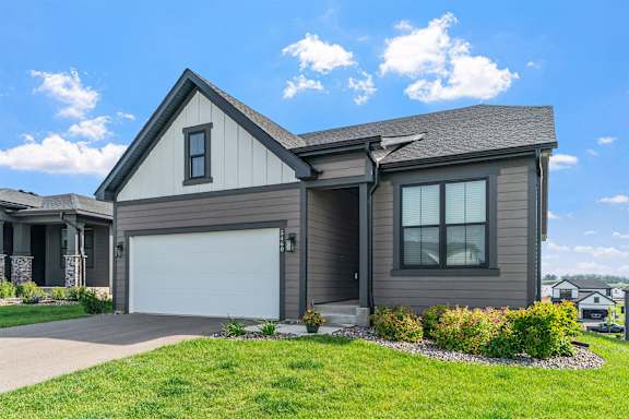 A house with a garage door and a driveway.