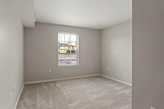 A room with a carpeted floor and a window.