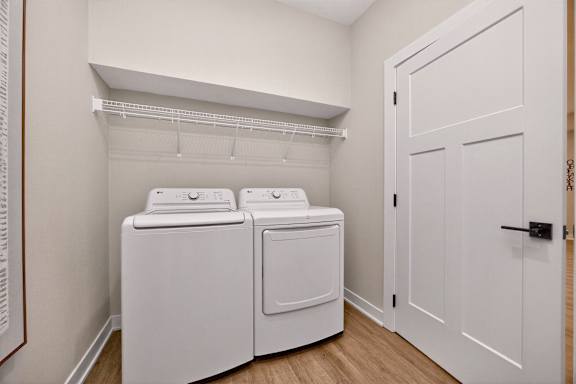 A white laundry room with a washer and dryer.