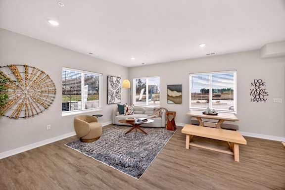 A living room with a large rug and a wooden bench.