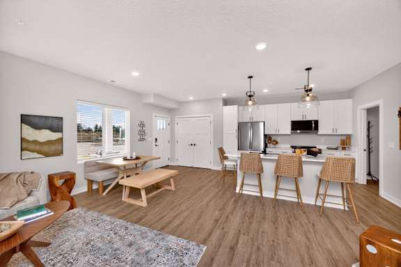 A modern kitchen with wooden floors and furniture.