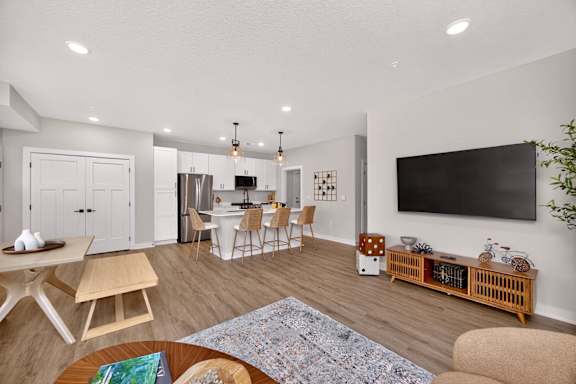 A modern living room with a dining area and a kitchen in the background.