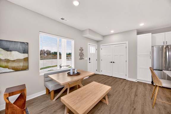 A modern dining room with a wooden table and chairs.