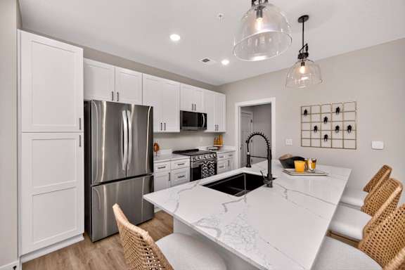 A modern kitchen with a white marble countertop and stainless steel appliances.