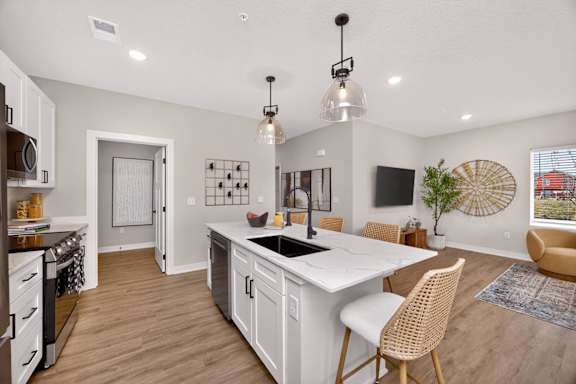 A kitchen with a white island and wooden floors.