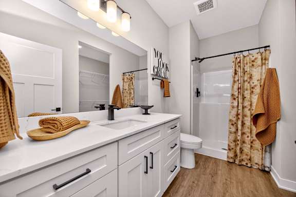A bathroom with a white counter top and a white toilet.