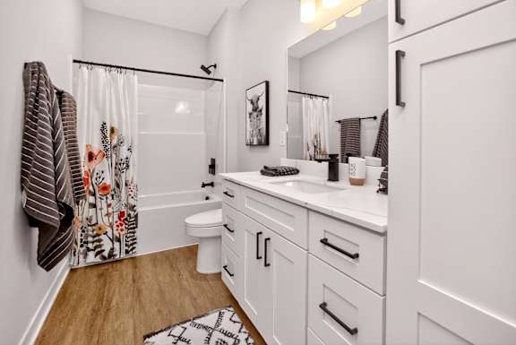 A white bathroom with a towel hanging on the wall.