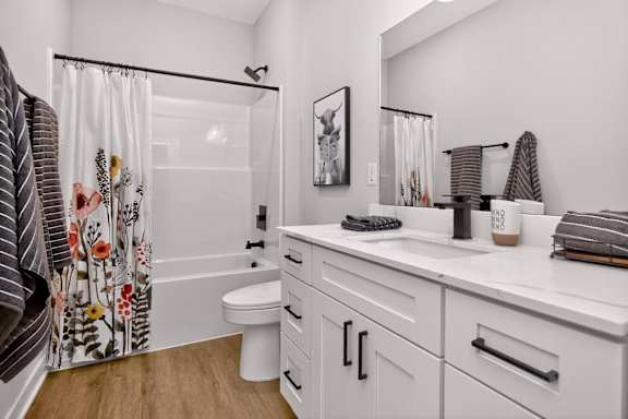 A white bathroom with a toilet, sink, and shower.