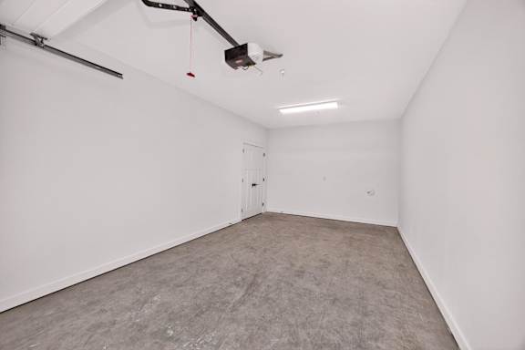 A room with a grey carpet and a white door.