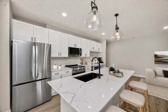 A modern kitchen with a marble countertop and stainless steel appliances.