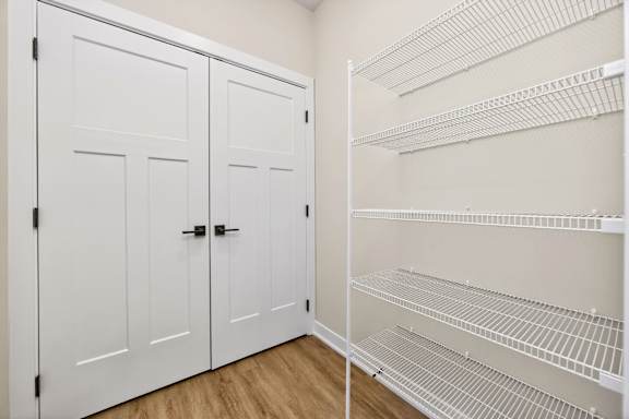 A white closet with shelves and doors.