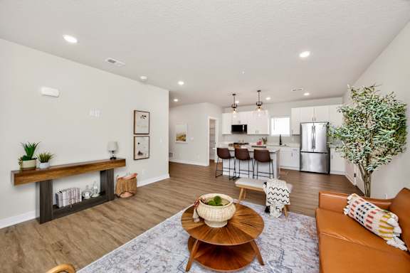 A living room with a brown coffee table and a brown couch.