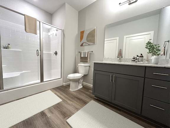 A bathroom with a toilet, sink, and shower.