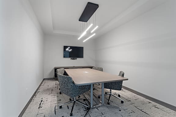 A conference room with a long table and chairs.