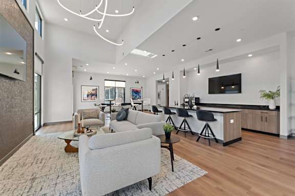 A modern living room with a grey sofa and a wooden floor.