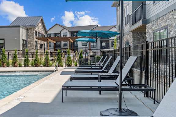 A poolside area with sun loungers and a pool.