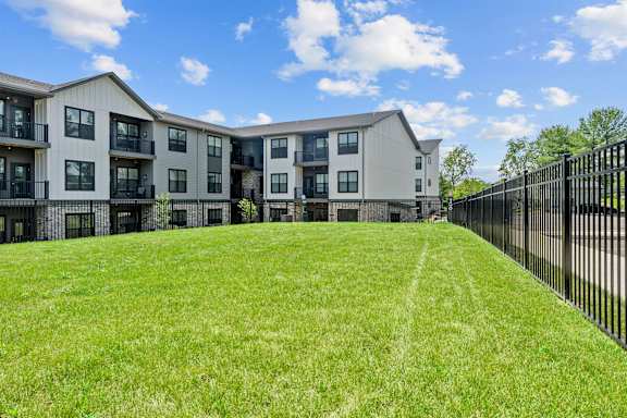 A large grassy area in front of apartment buildings.