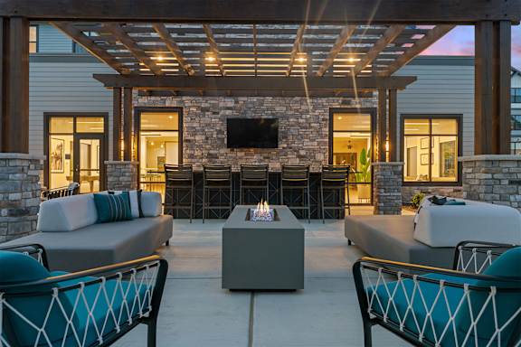 A patio with a stone fireplace and seating area.