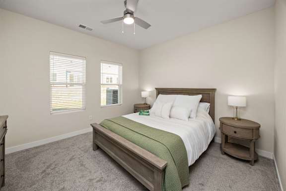A bedroom with a bed, nightstand, and window.