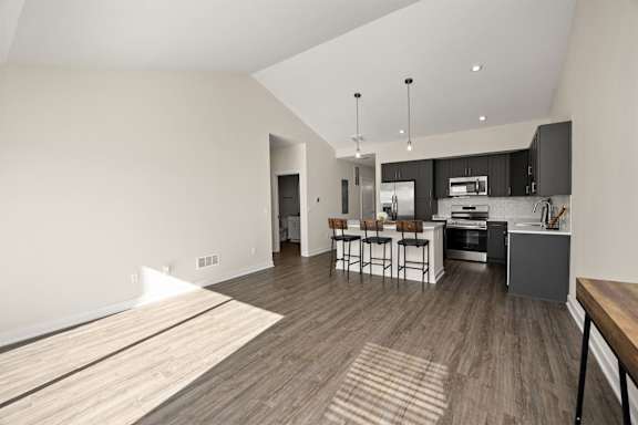 A modern kitchen with dark wood floors and a white ceiling.