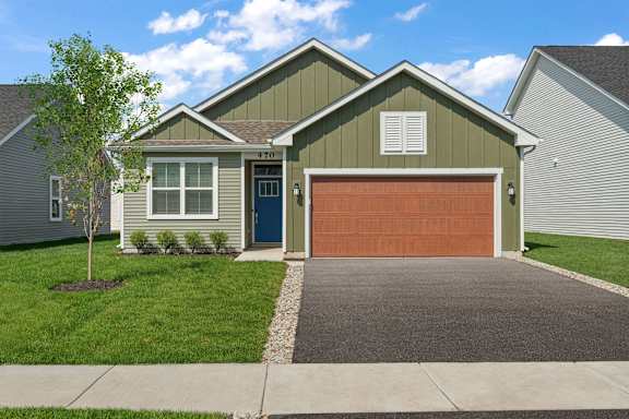 A house with a garage door and a driveway.