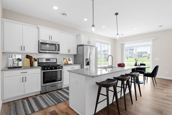an open kitchen with a large island with bar stools