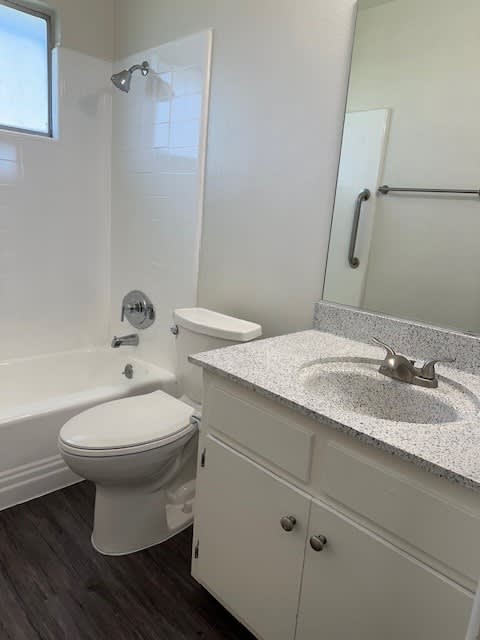 A white toilet sits next to a sink in a bathroom.