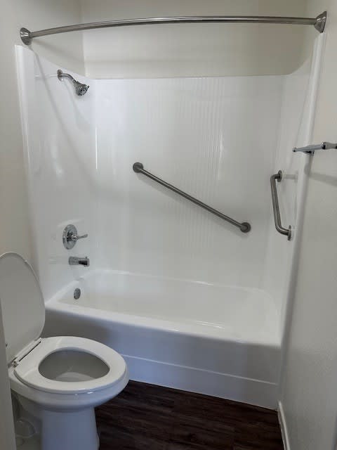 A white toilet is next to a white bathtub in a bathroom.