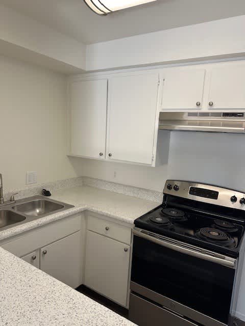 A kitchen with a stove and sink.