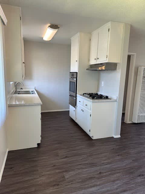 A kitchen with white appliances and cabinets.