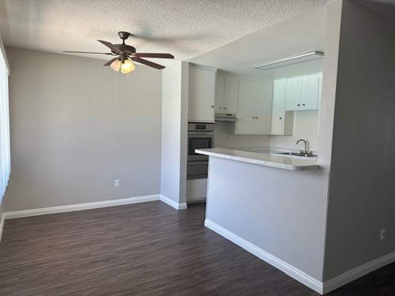 A kitchen with a fan on the ceiling and a counter.
