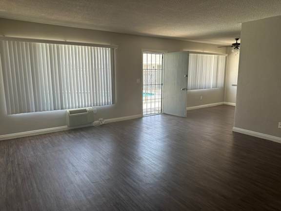 A room with wooden floors and a window with blinds.
