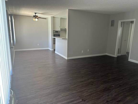 A room with wooden floors and a ceiling fan.